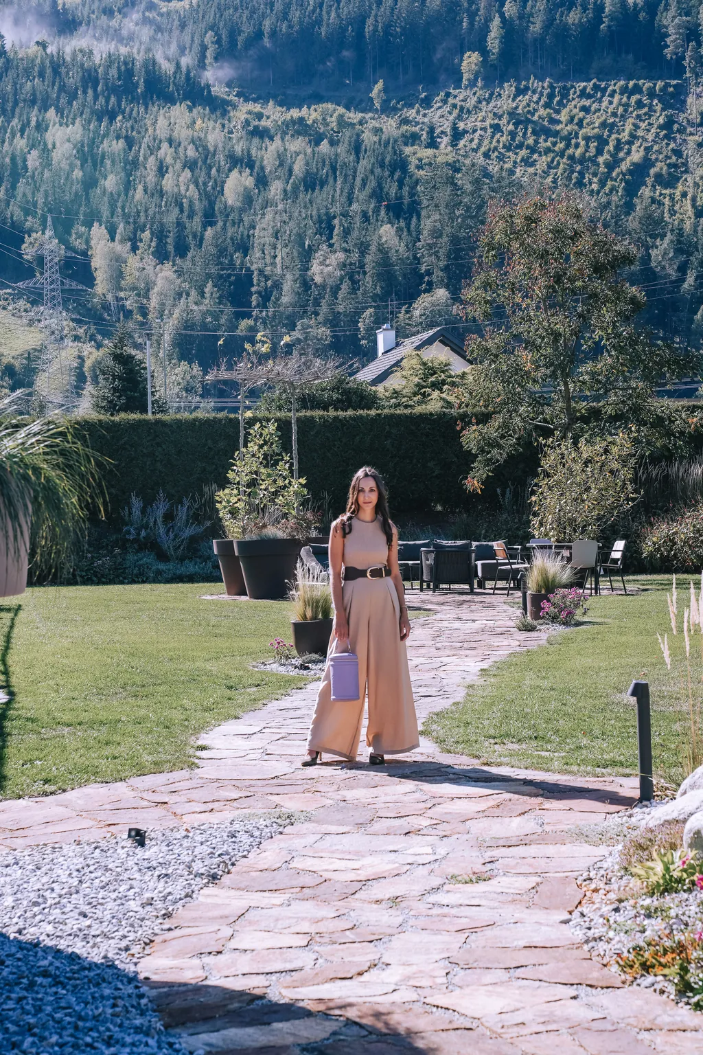 Sophie auf einem Steinweg im Garten, dahinter die Berge der Obersteiermark