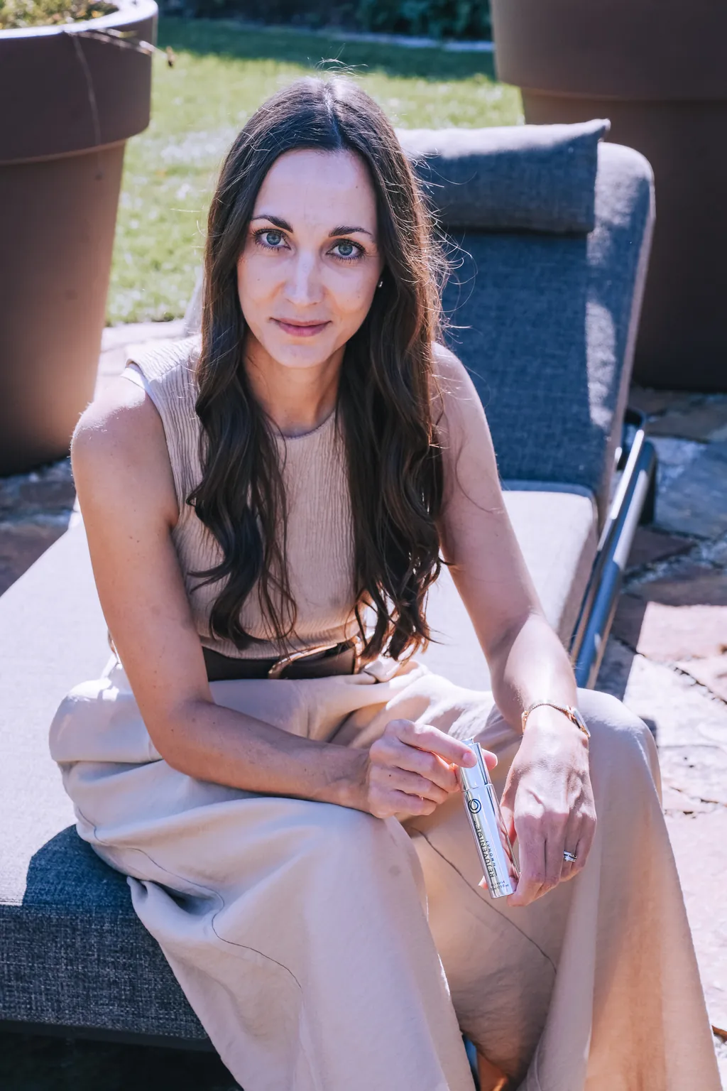Sophie Täubl lächelt auf einer Gartenliege in der Sonne
