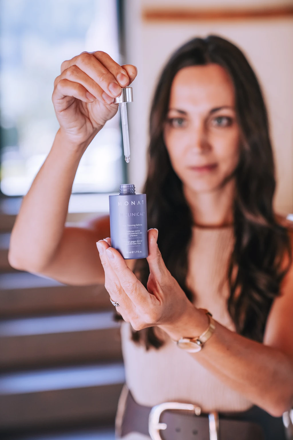 Sophie hält eine MONAT Serumflasche mit Pipette