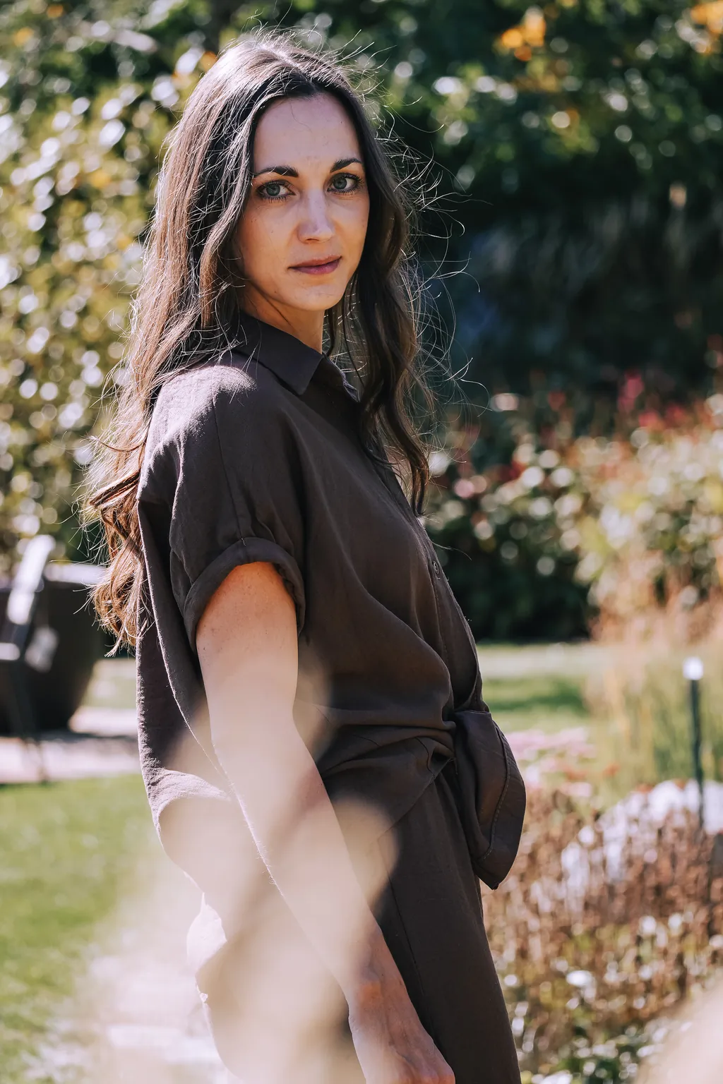 Sophie im Garten, die langen dunklen Haare fallen über die Schulter