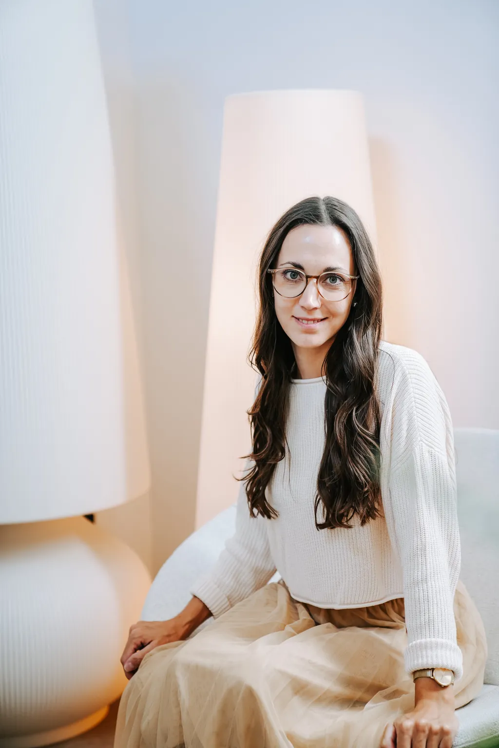 Sophie mit Brille sitzt in einem hellen Sessel